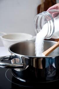 Sugar pouring into saucepan.
