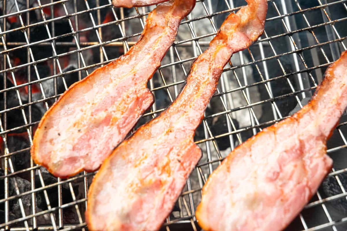 Bacon on a grill mat on the grill.