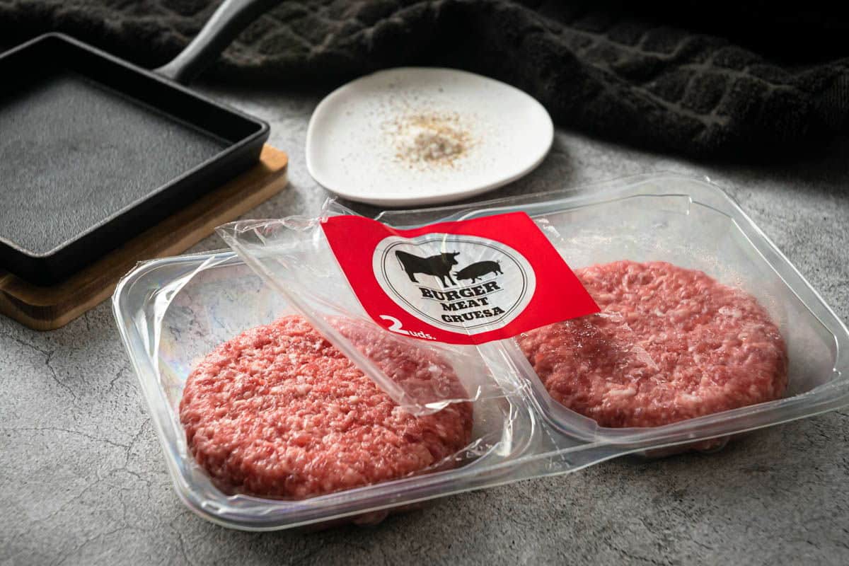 Raw burger patties in a package.