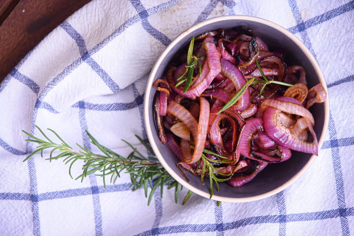 Grilled, sliced red onions in bowl.
