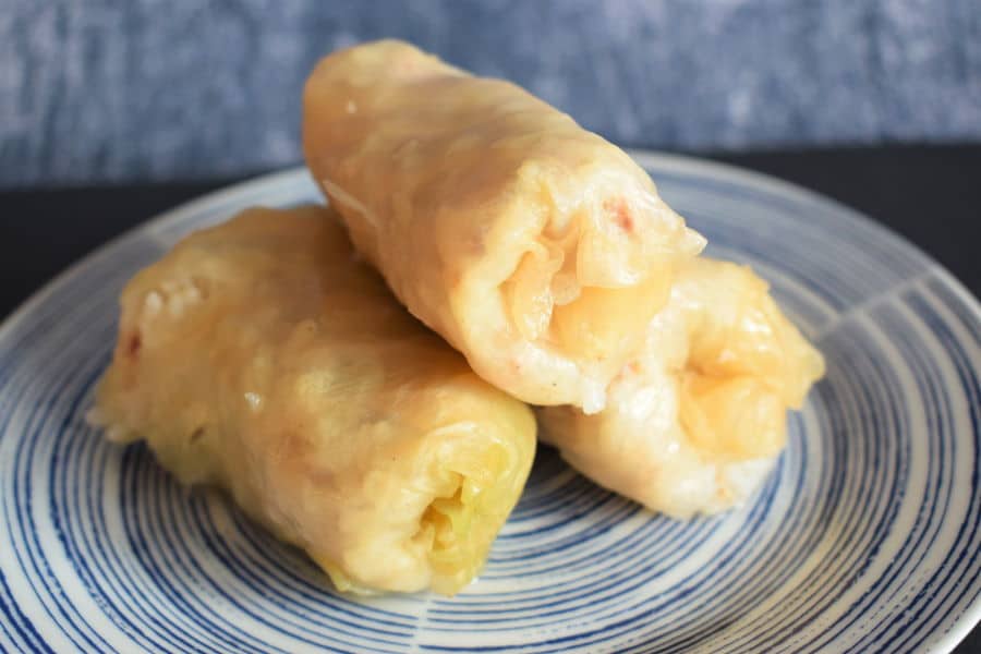 Cabbage rolls on a blue and white plate, blue background.
