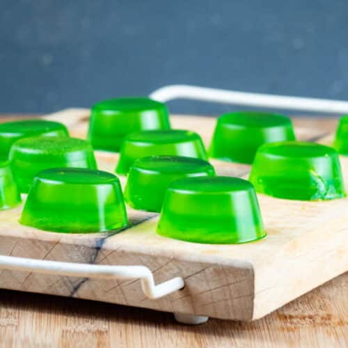 Green gummies drying on a cutting board.