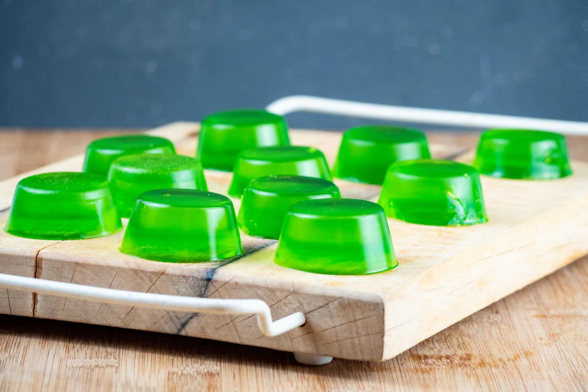Green gummies drying on a cutting board.