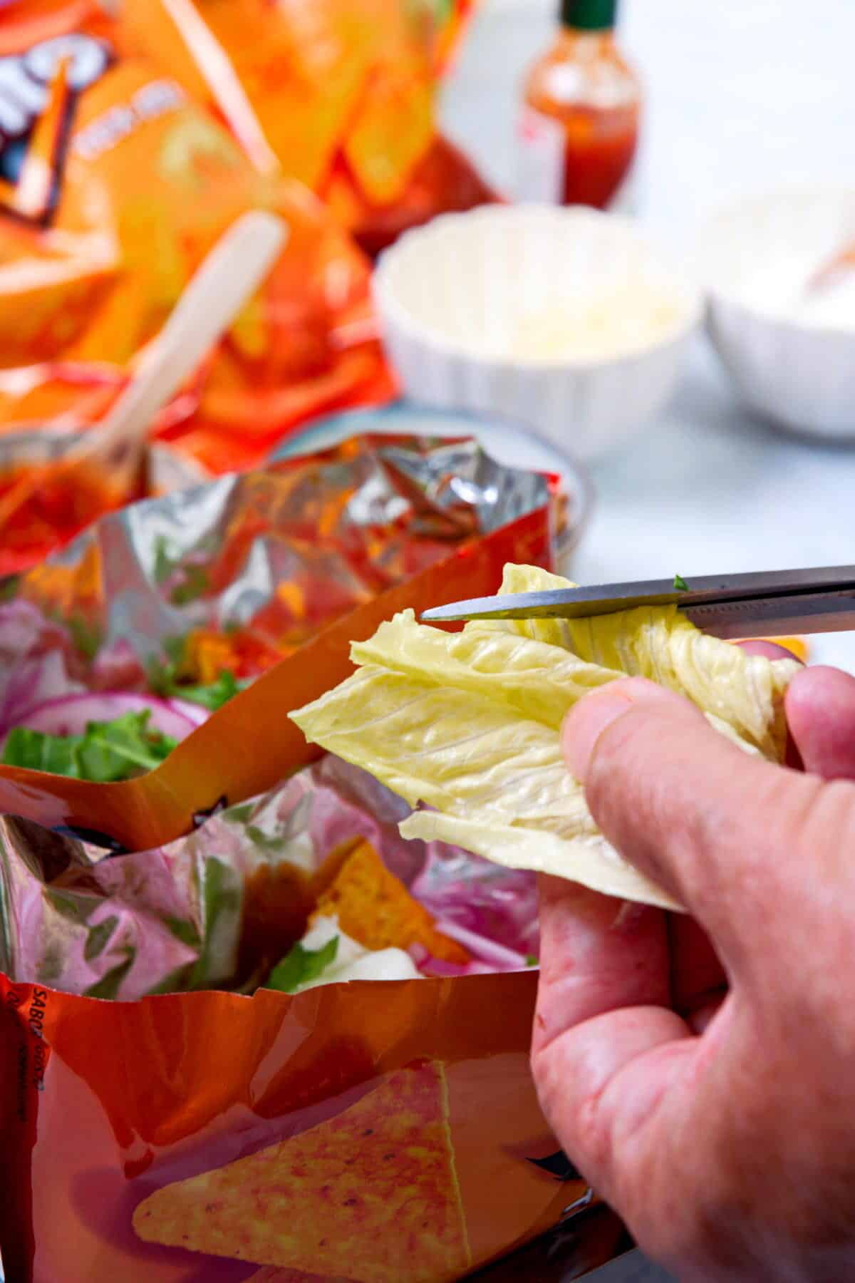 Open Dorito bags with taco filling and lettuce.