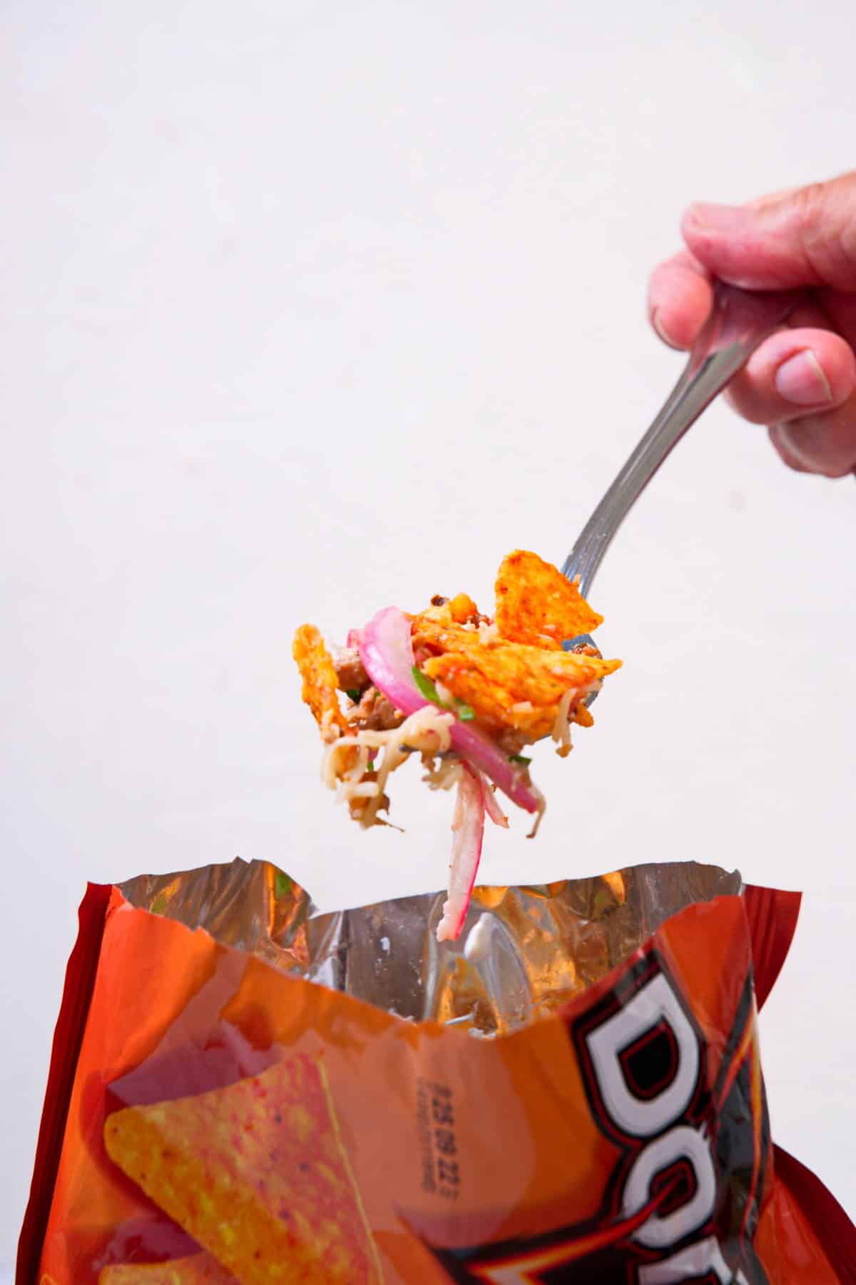 Taco in a bag with a fork on white background.