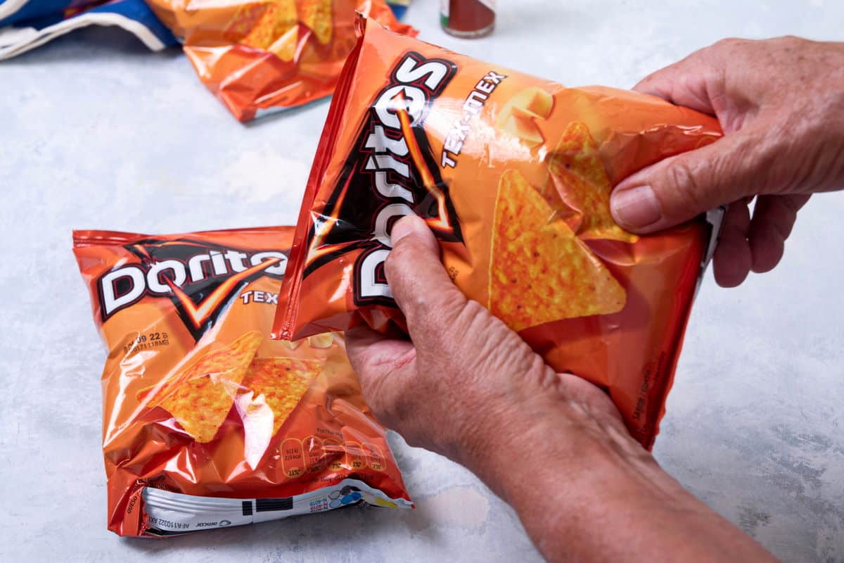 A small bag of Doritos in woman's hands.
