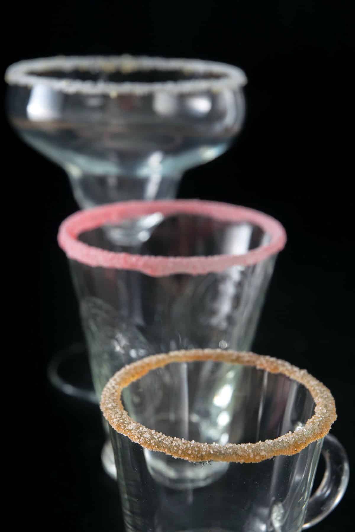 3 glasses with sugar rims on black background.