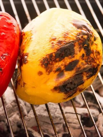 3 charred bell peppers on the grill.