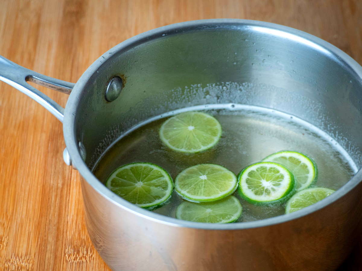 Lime slices in a pot, wooden background.