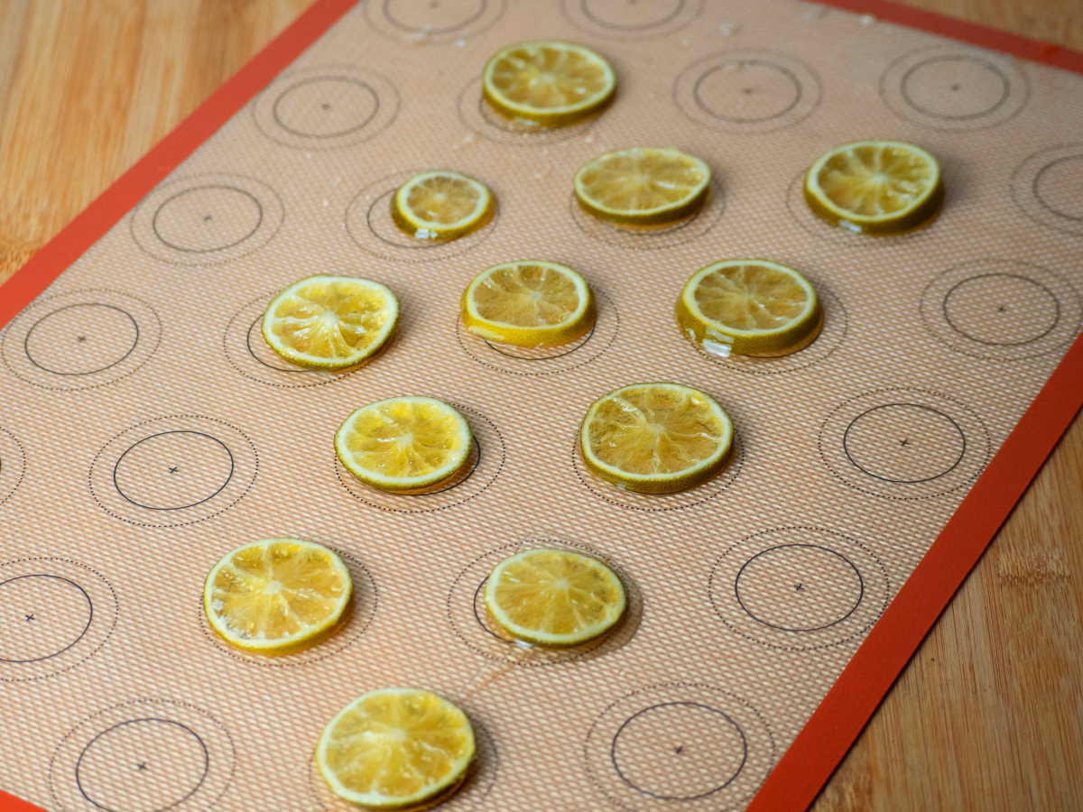 Candied limes sitting on a silicone mat.