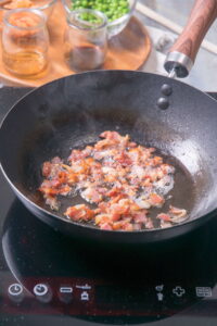 Chopped bacon in frying pan.