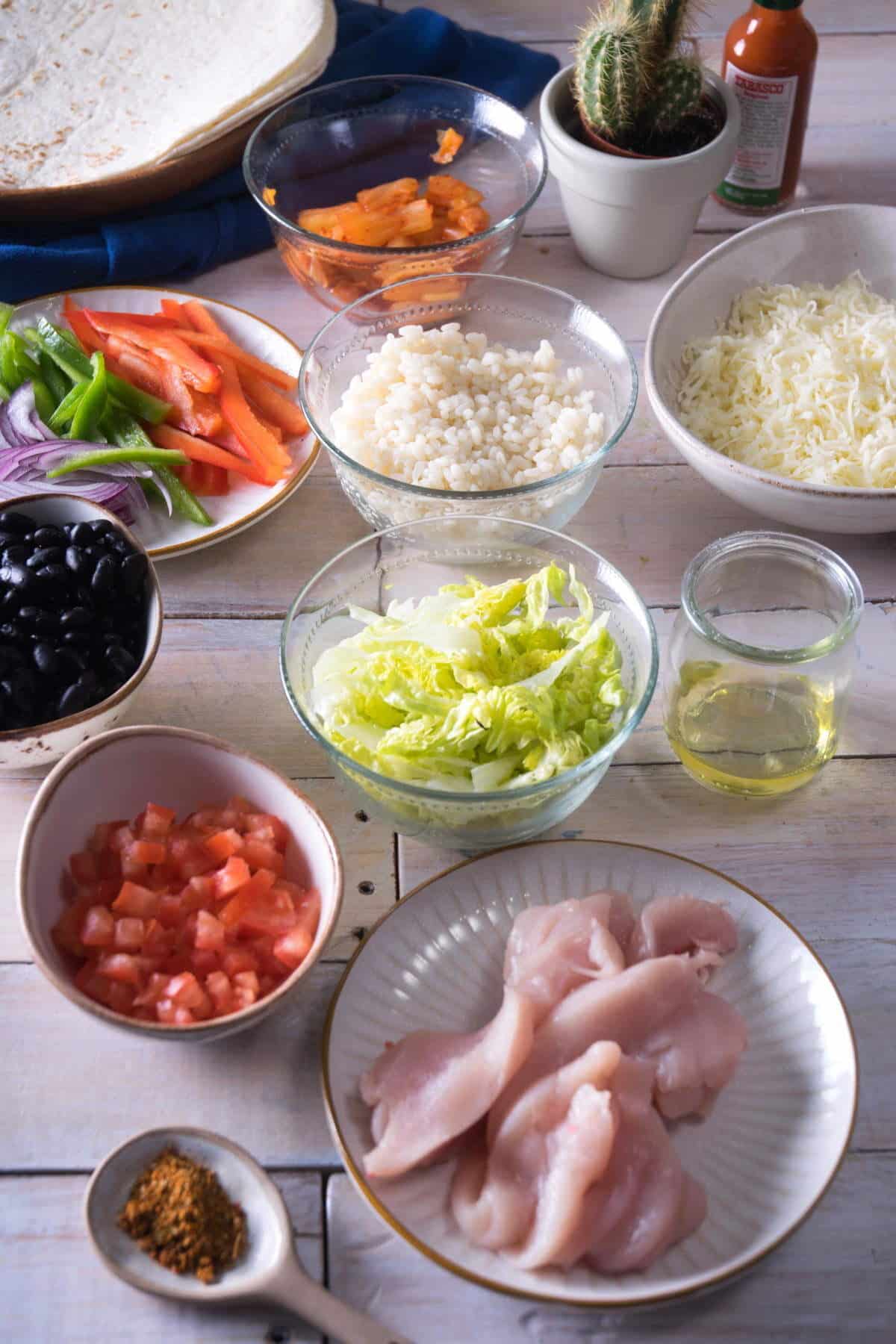 Kimchi burrito ingredients in bowls on wooden background.