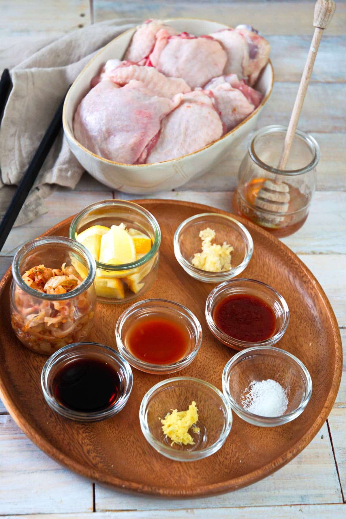 Kimchi chicken ingredients prepped on wooden background.