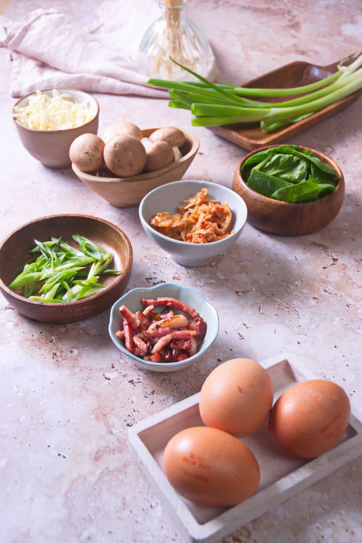 Prepped kimchi omelette ingredients on marble background.