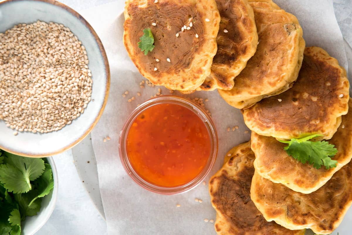 Kimchi pancakes with sweet and sour sauce and sesame seeds.