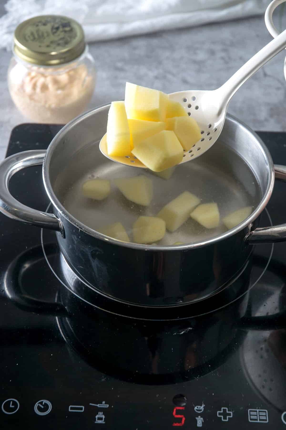 Raw, cubed potatoes in a pot.