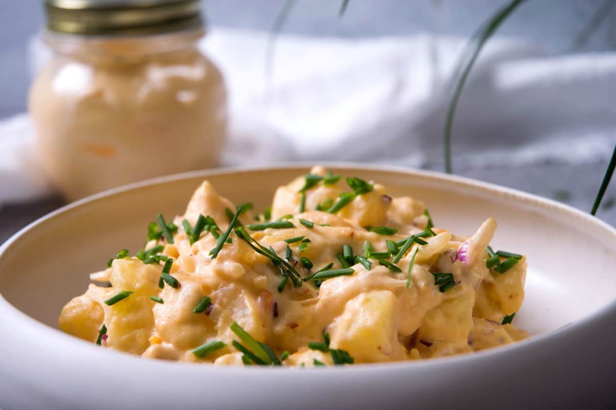 Kimchi potato salad in white bowl.