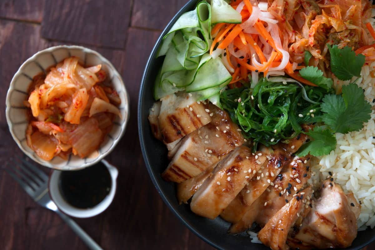 Kimchi rice bowl on wooden background, overhead view.