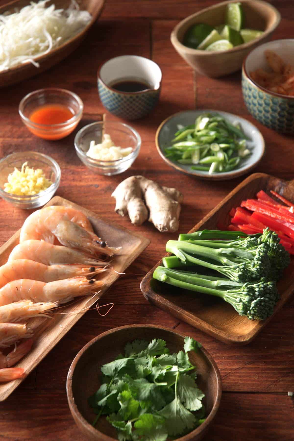 Kimchi shrimp stir fry ingredients prepped on dark wooden background.