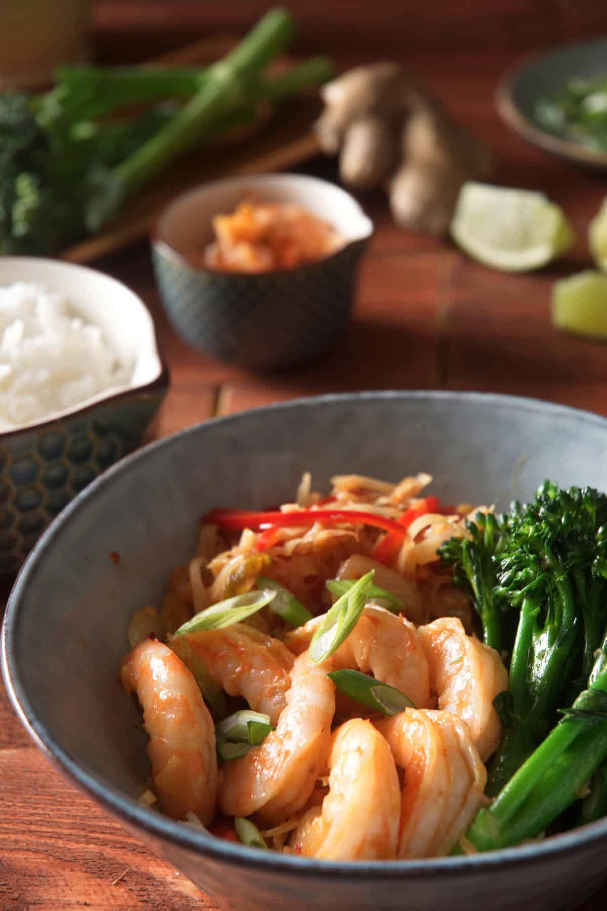 Kimchi shrimp stir fry over rice in a bowl, close up.