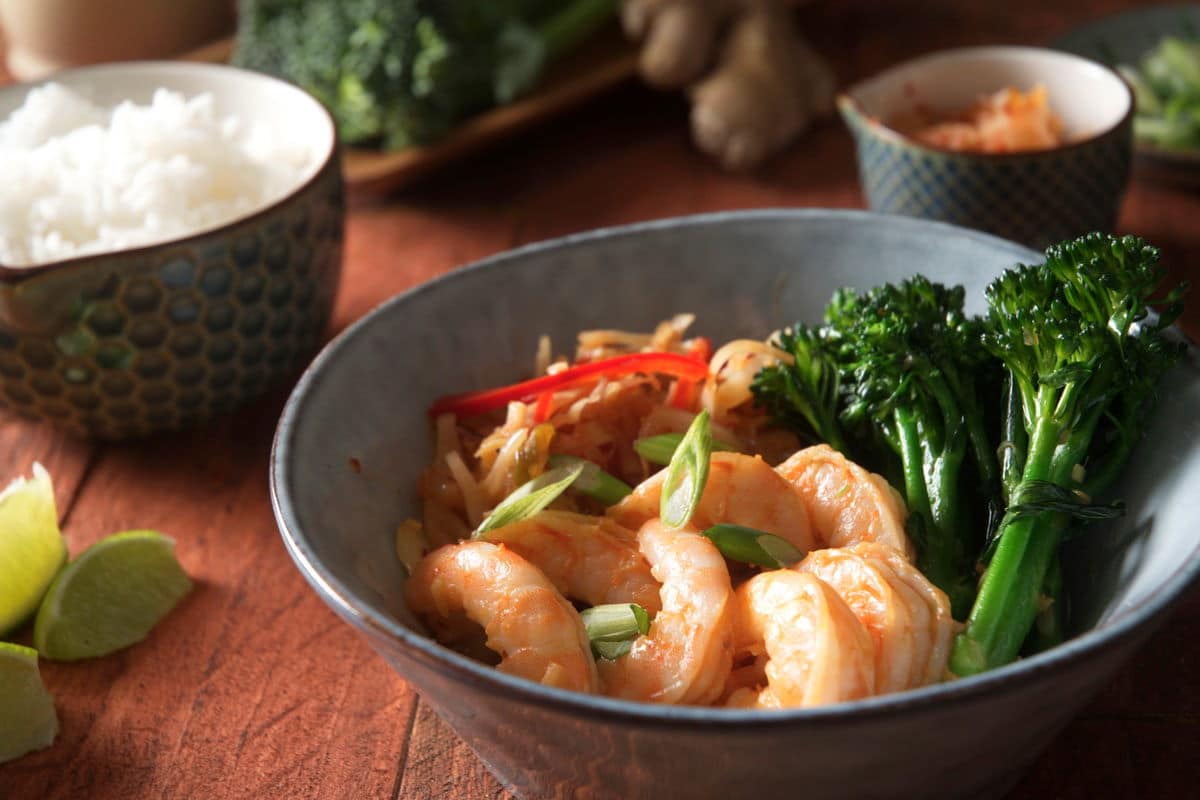 Kimchi shrimp stir fry over rice in a bowl, close up.