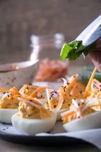 Kimchi deviled eggs on a plate.