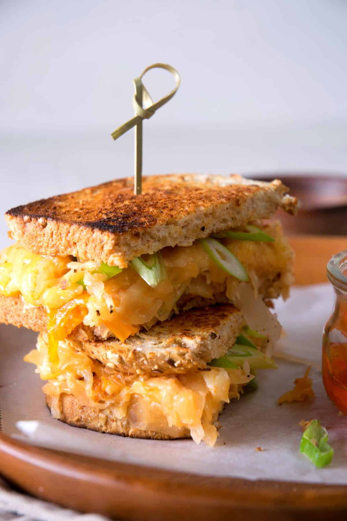 Kimchi grilled cheese sandwiches on a brown plate.
