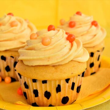 Pumpkin cupcakes on yellow plate.