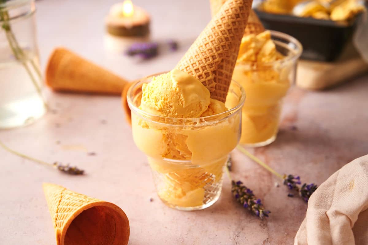 Mac and cheese ice cream in an ice cream glass with a waffle cone.