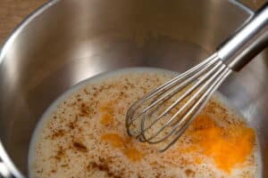 Milk, pumpkin pie spice and puree in a saucepan with a whisk.