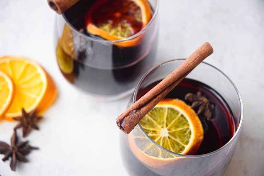 Electric Skillet Mulled Wine in wine glasses with orange slices and cinnamon sticks.