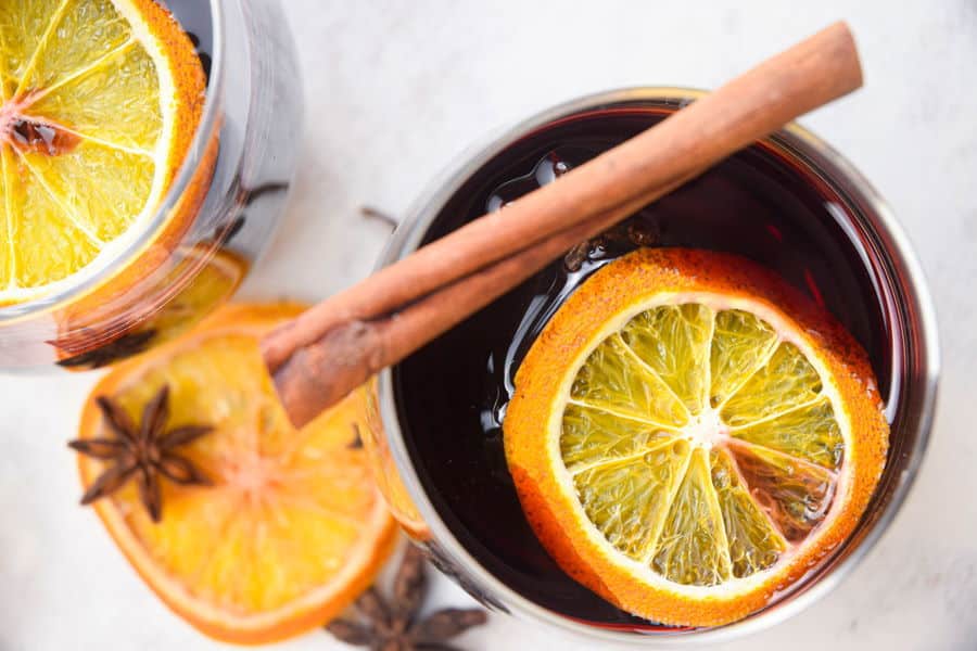 Electric Skillet Mulled Wine in wine glasses with orange slices and cinnamon sticks.
