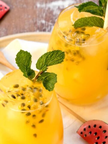 Passion fruit mojitos in glasses with watermelon swizzle sticks.