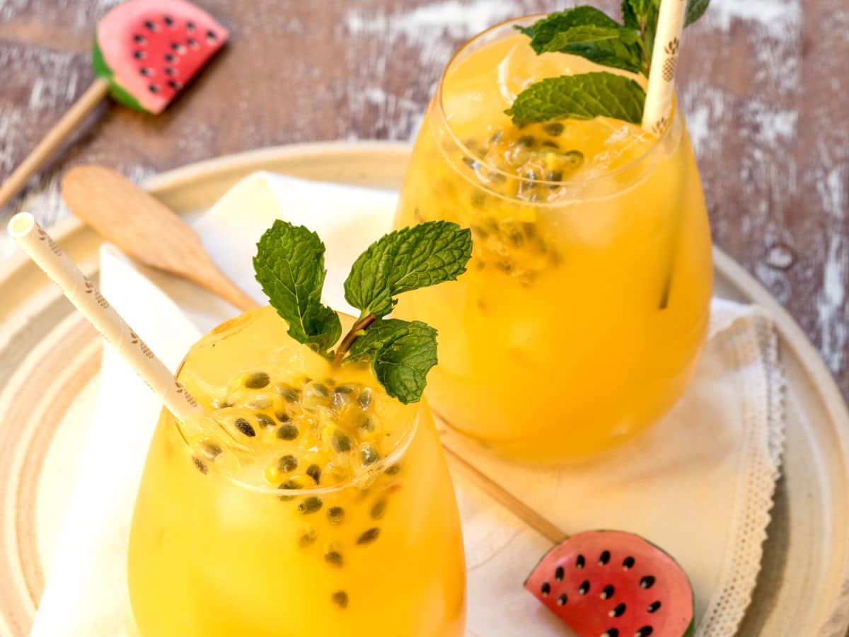 Passion fruit mojitos in glasses with watermelon swizzle sticks.