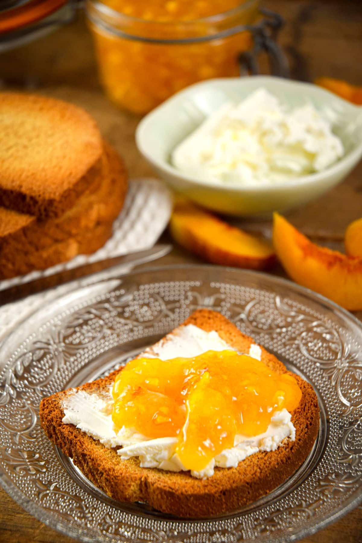 Peach freezer jam and cream cheese on a piece of toast.