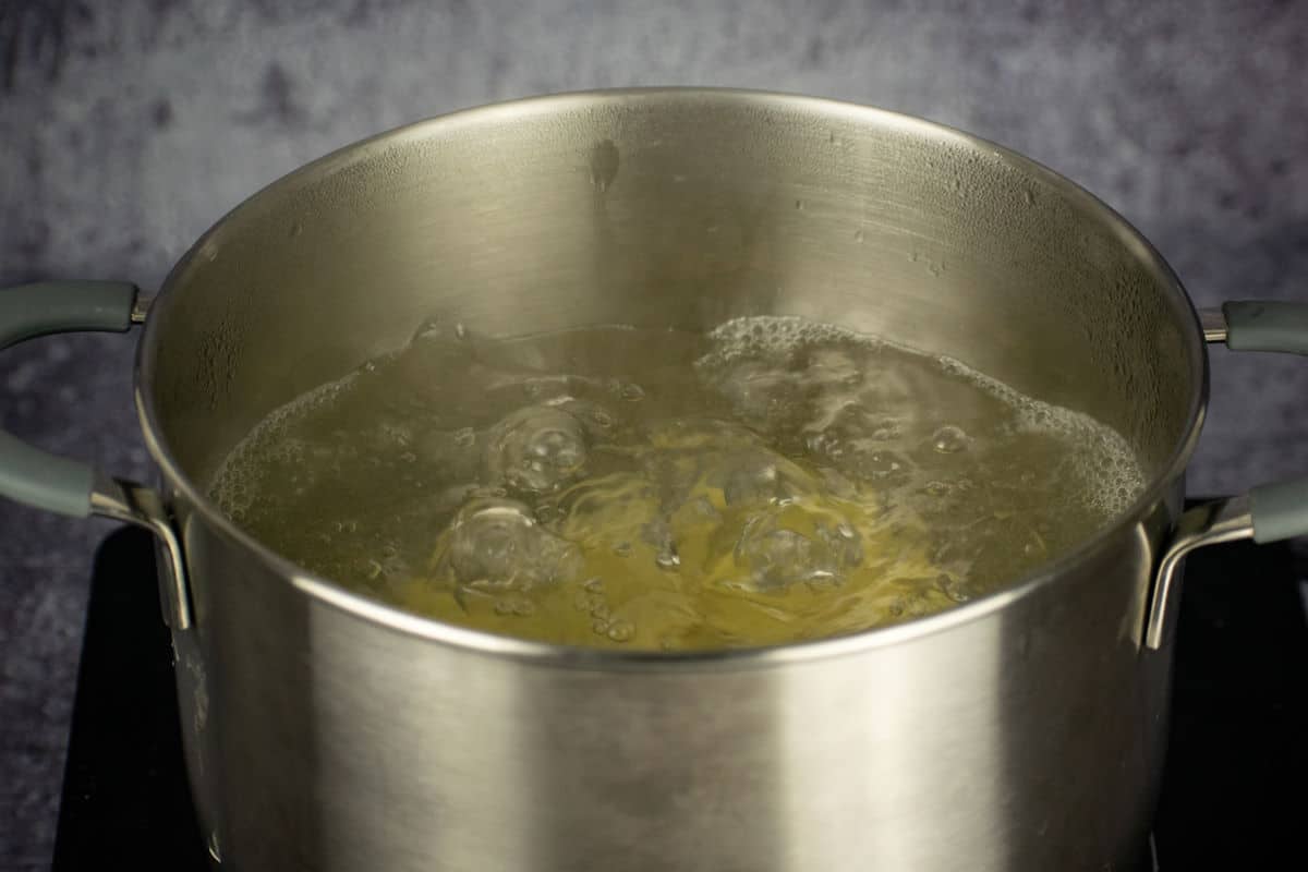 Potatoes boiling in pot of water.