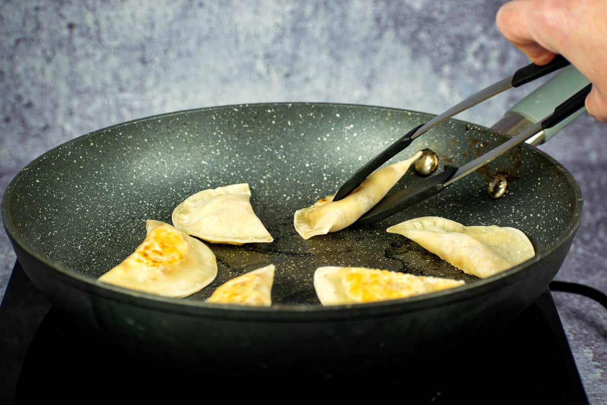 Pan with golden pierogies in it.