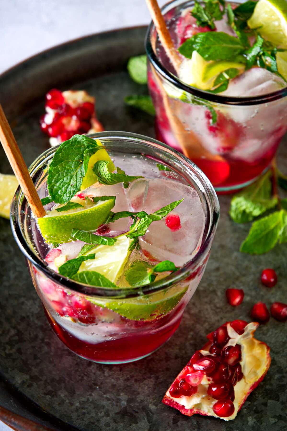 Pomegranate mojito mocktails on a tray.