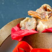 Praline pecans in gift box with red ribbon.