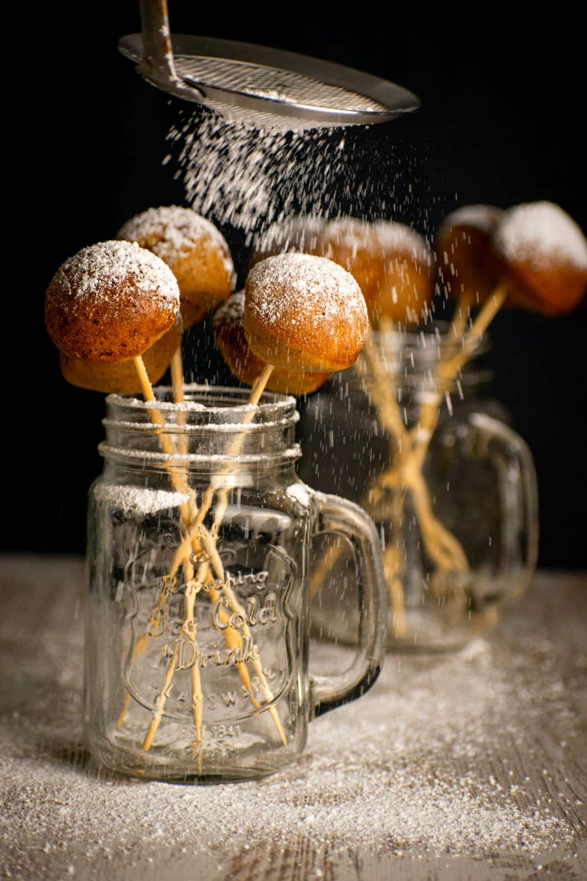 Pumpkin cake pops in a jar with powdered sugar.