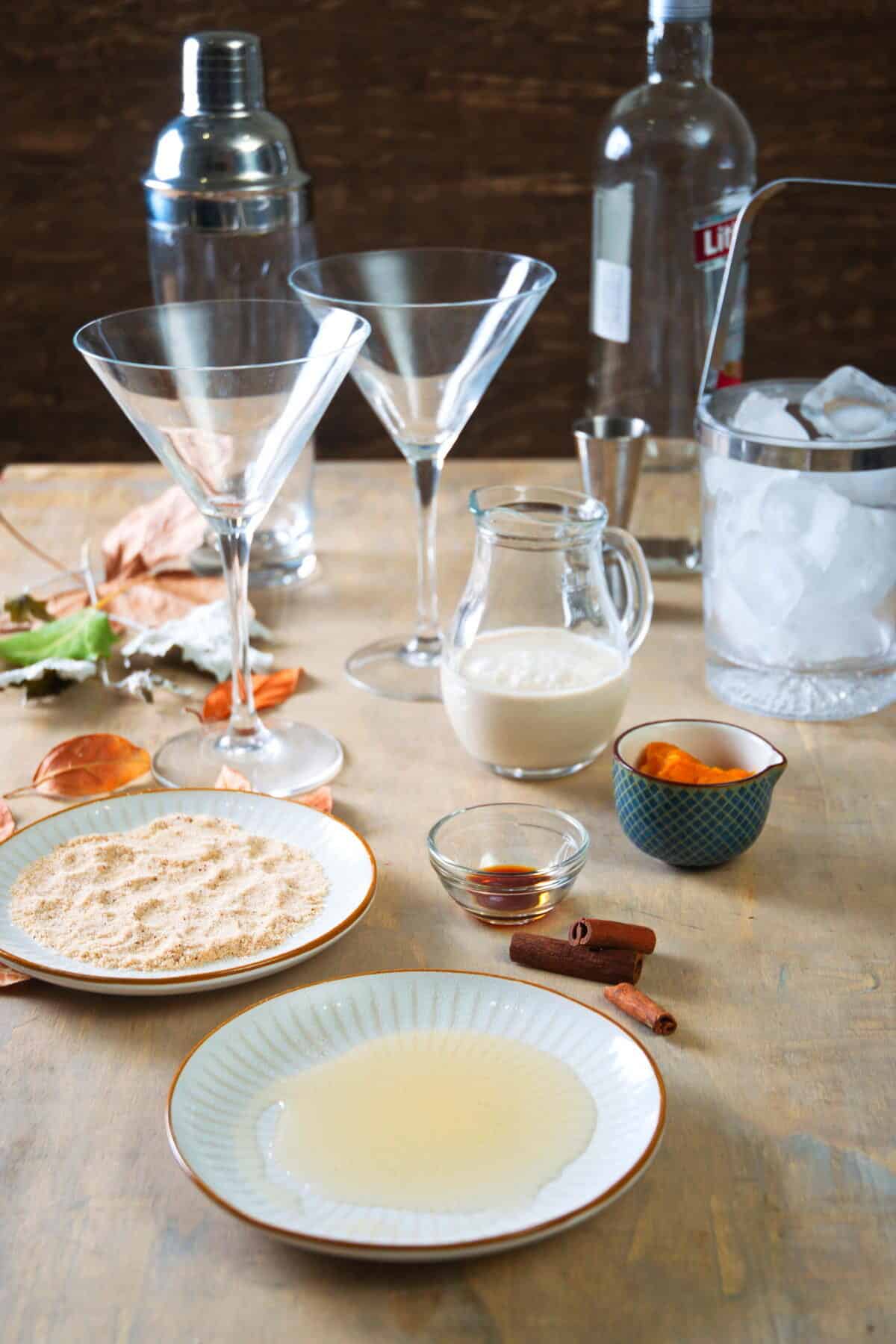 Pumpkin martini ingredients prepped on wooden background.