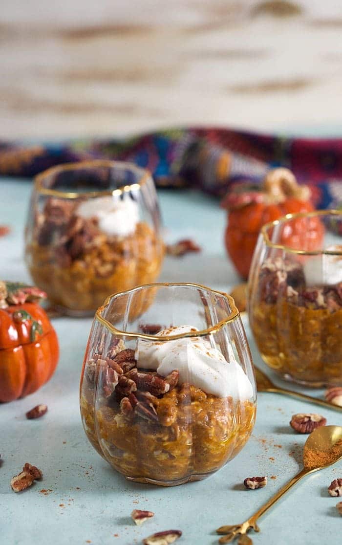 Pumpkin overnight oats in clear glass dessert dishes.