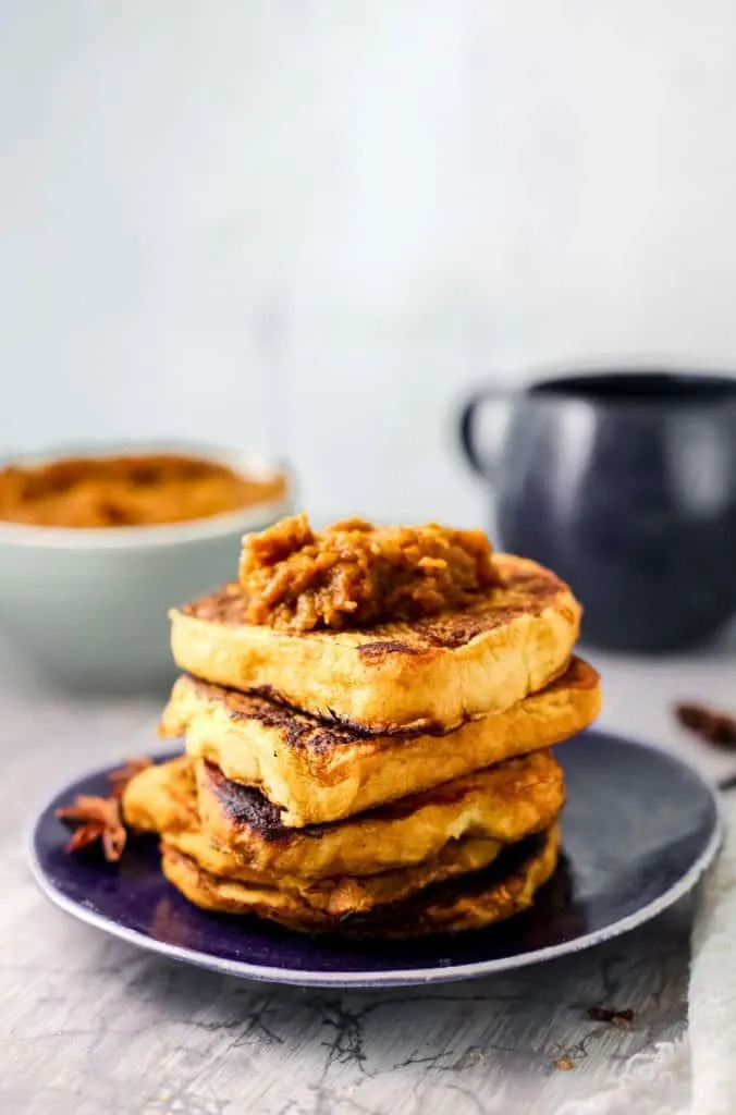 Pumpkin French toast stacked on a dark blue plate.