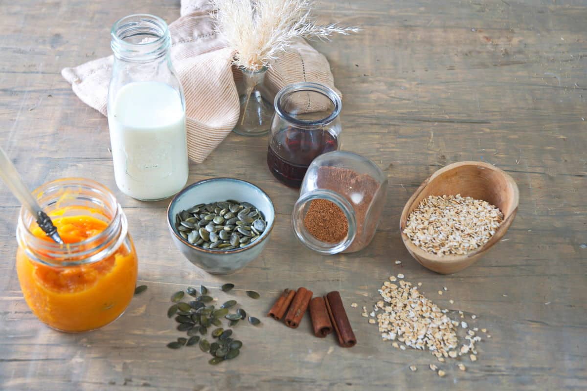 Pumpkin oatmeal ingredients prepped on marble background.