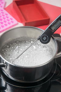 Candy mixture in a saucepan with a thermometer.