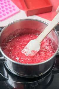 Candy mix in a saucepan with a spatula.