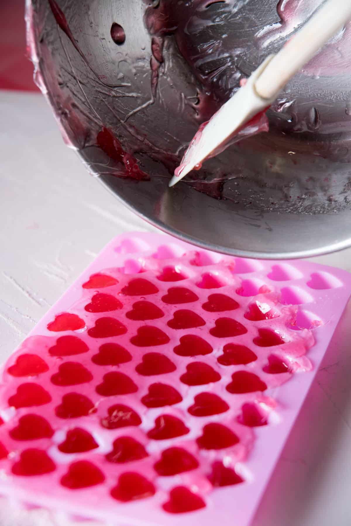 Strawberry hard candy mixture in a pink heart mold.