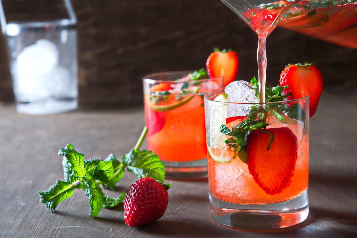 Strawberry mojito mocktails in glasses with fresh strawberries and mint on the side.