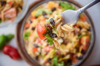 A close up of taco pasta salad on a fork.