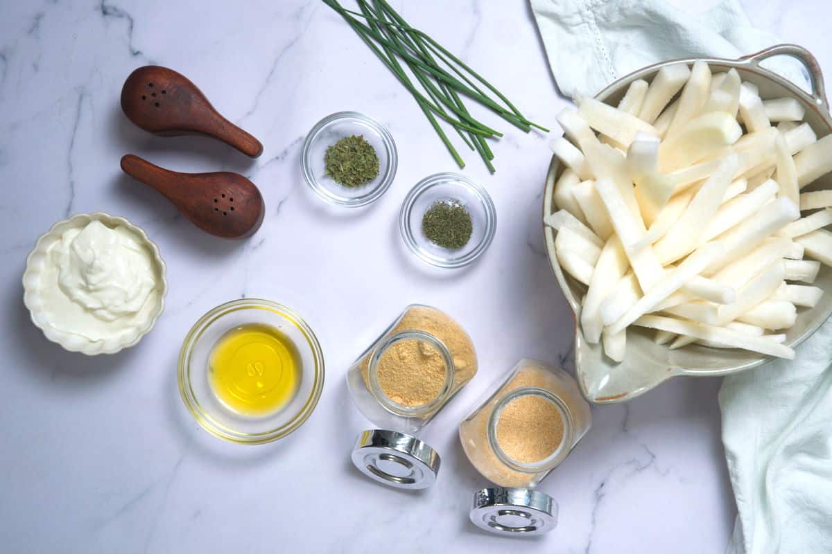 Raw turnip fries in bowl with chives, yogurt and spices on the side.